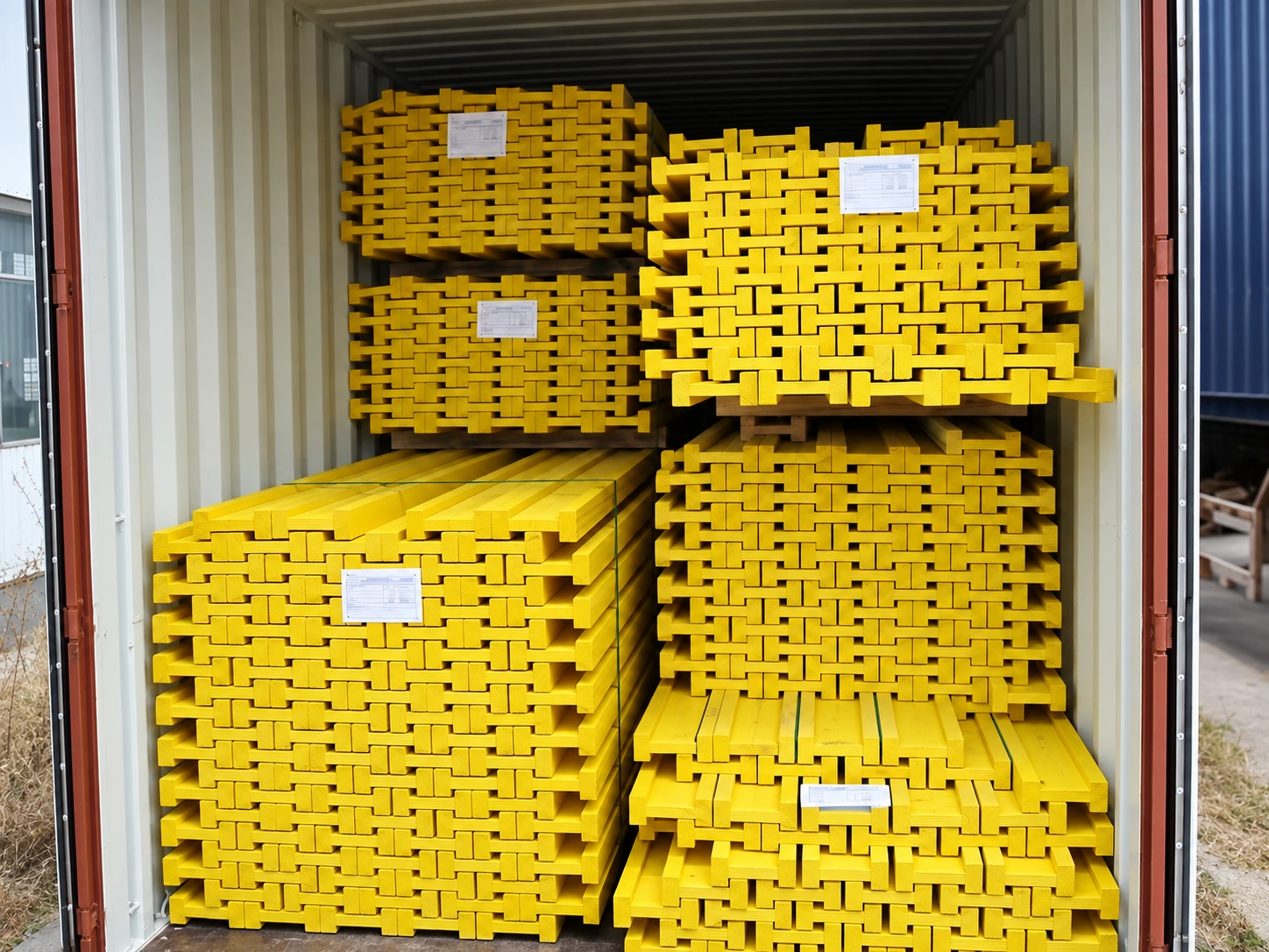 Container packed with yellow timber beams