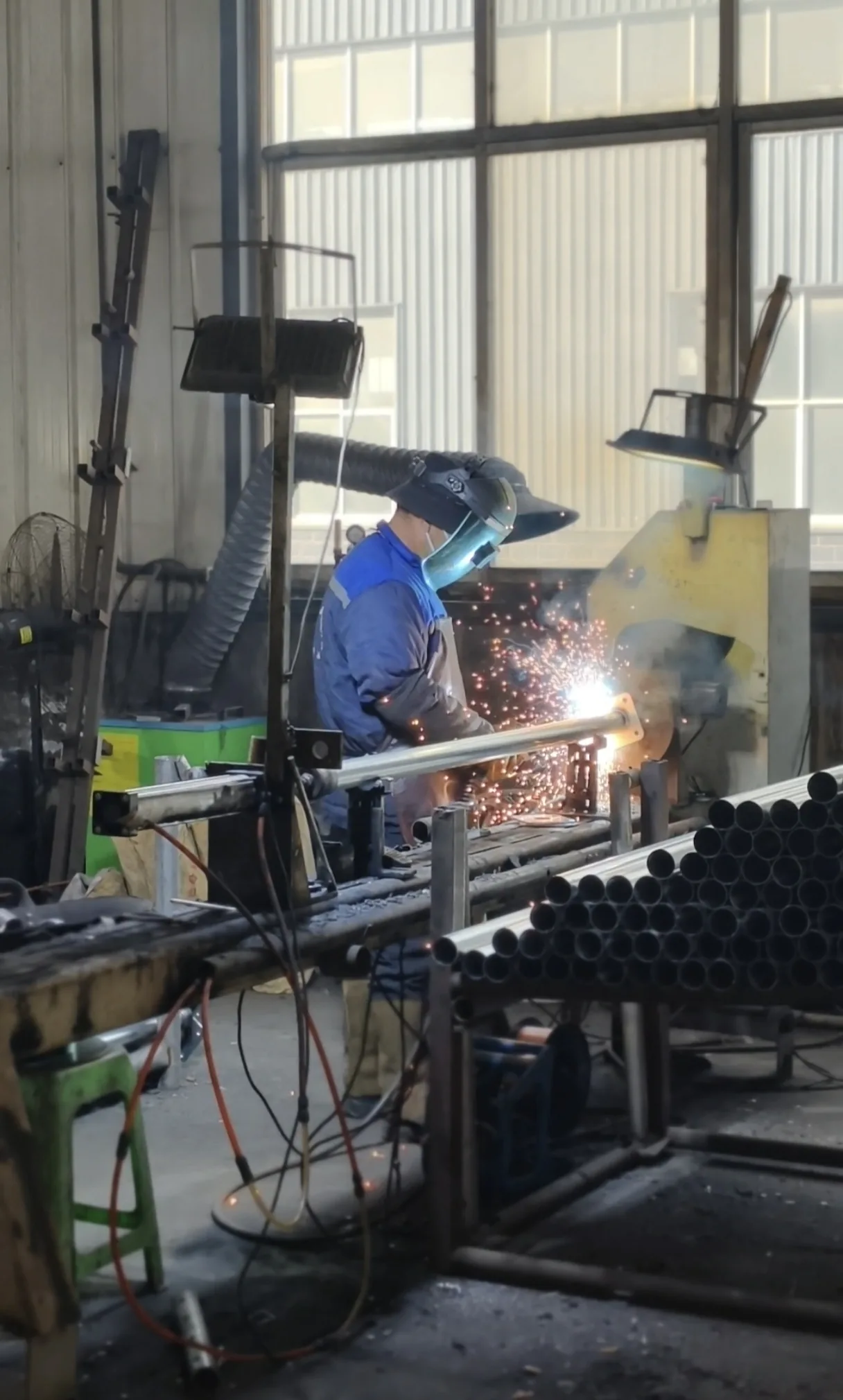 Skilled welder fabricating tubular construction-support components in the Hebei manufacturing base
