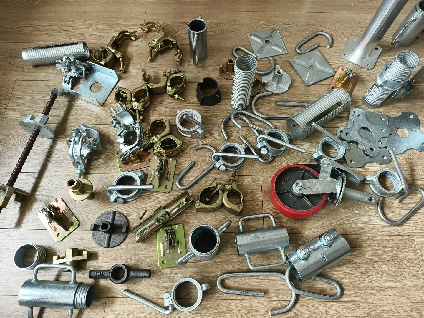 Real scaffolding and steel prop accessories arranged together on a wooden floor