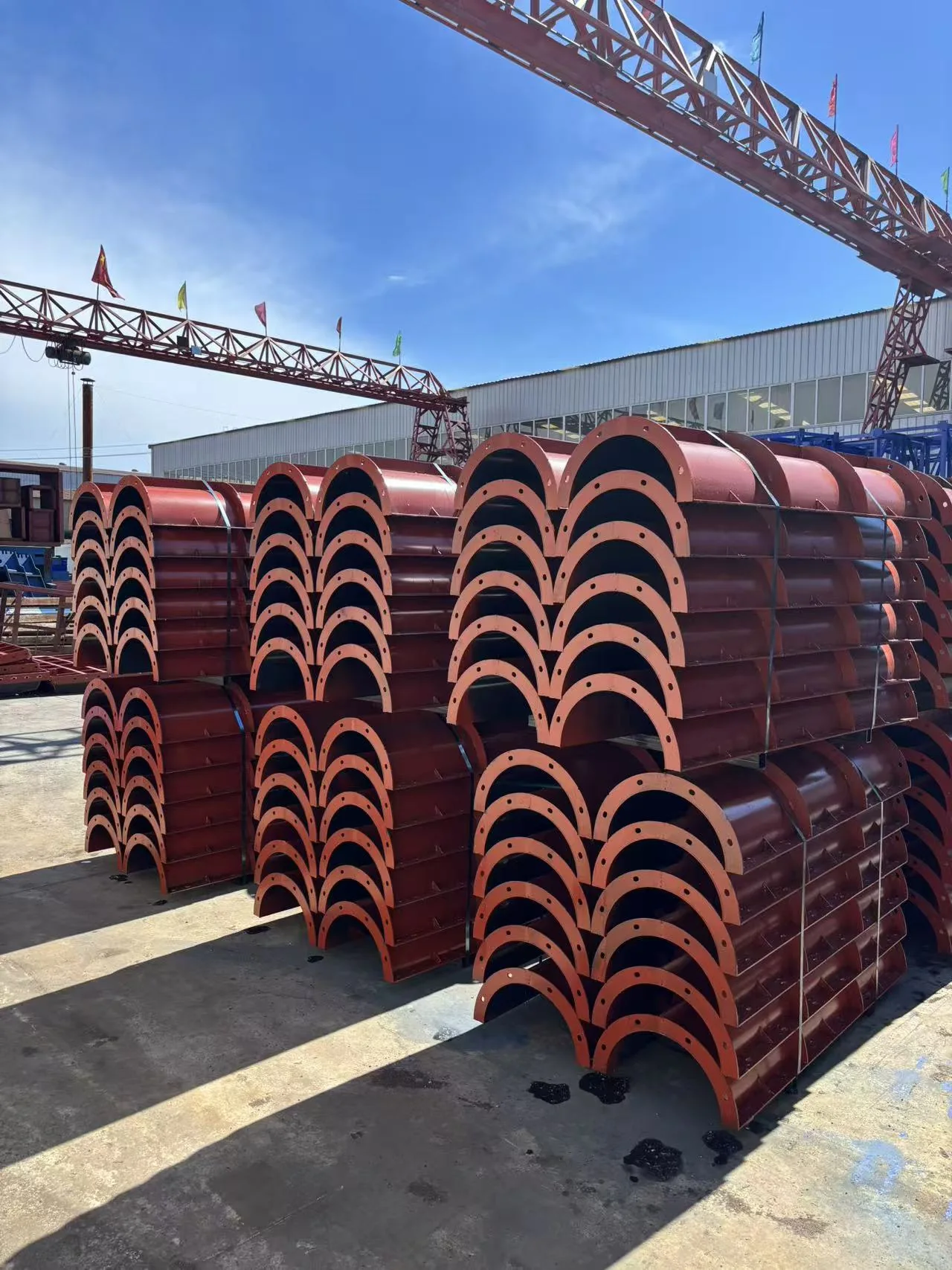 Finished circular column steel formwork half-shell sections stored outdoors