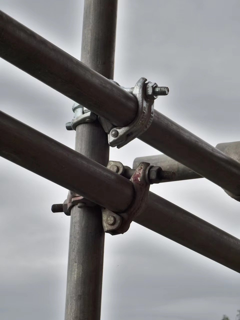 Forged couplers securing intersecting scaffold tubes