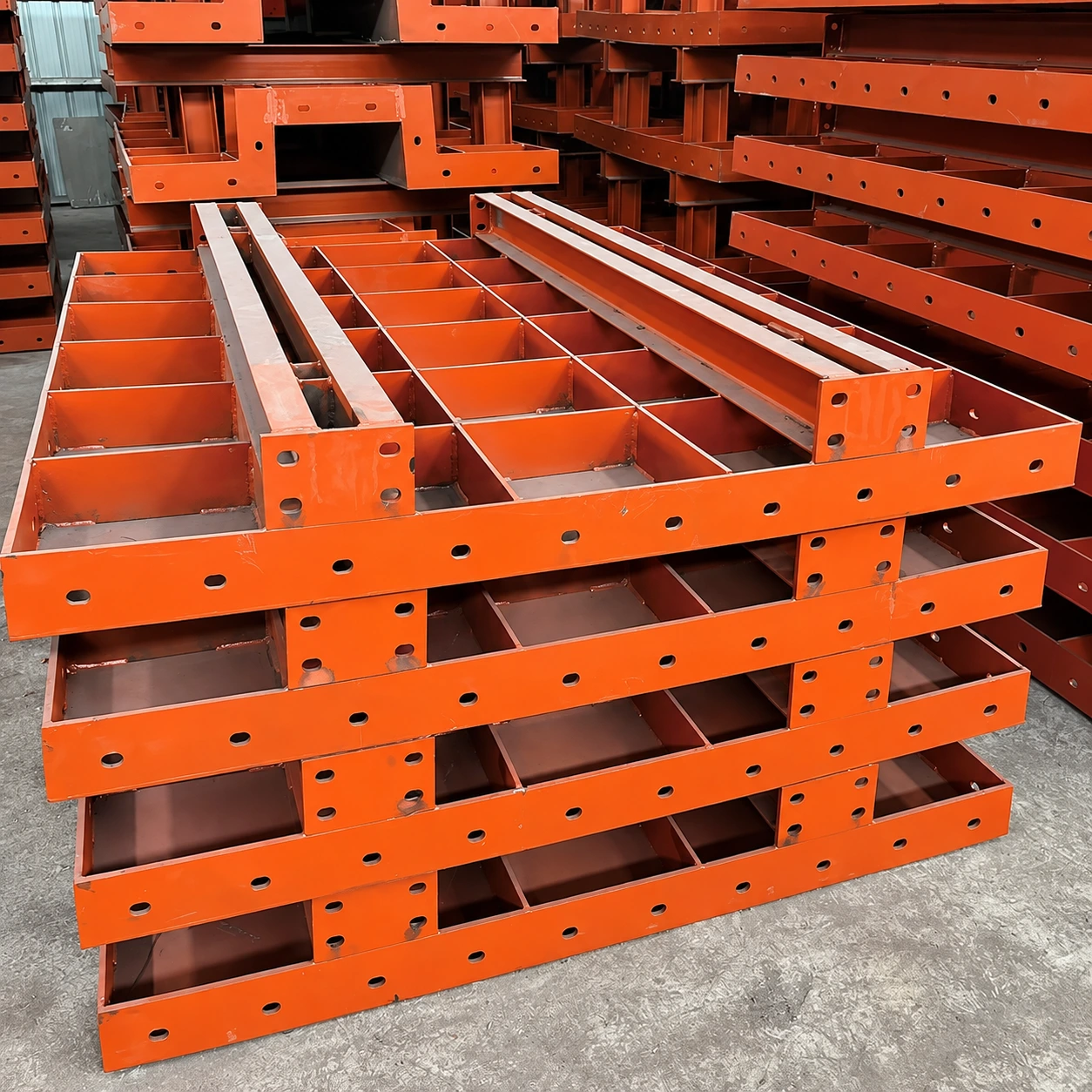 Orange steel formwork panels with stiffening ribs and edge connection holes